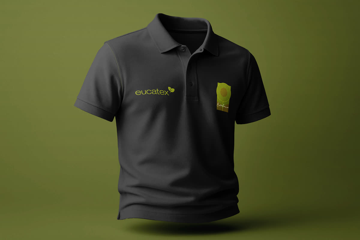 Camisa polo cinza-escura vestida, com o logotipo eucatex no peito e o selo Evoluir do lado direito, sobre fundo verde-oliva.