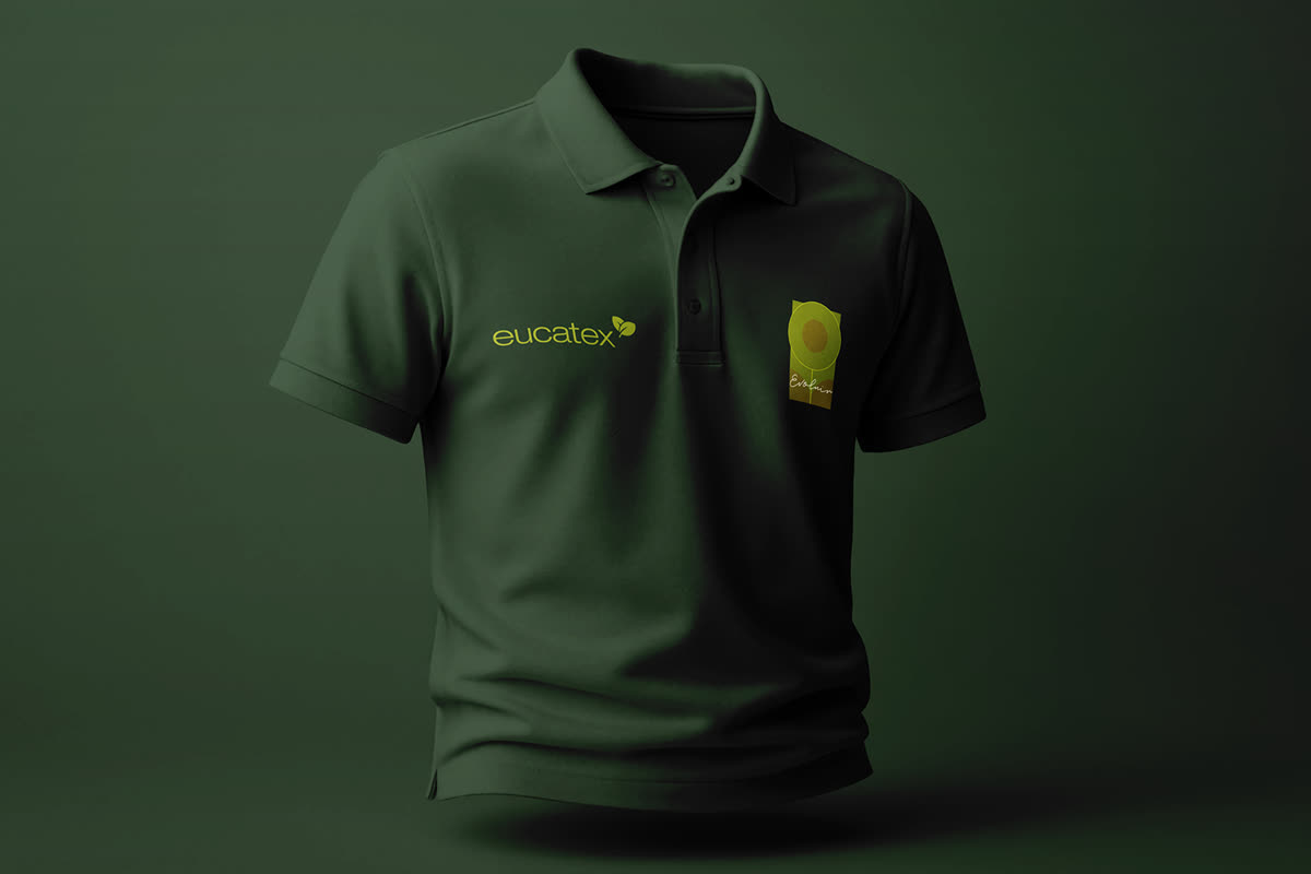 Camisa polo verde-escura vestida, com o logotipo eucatex e o selo Evoluir, sobre fundo verde-escuro.