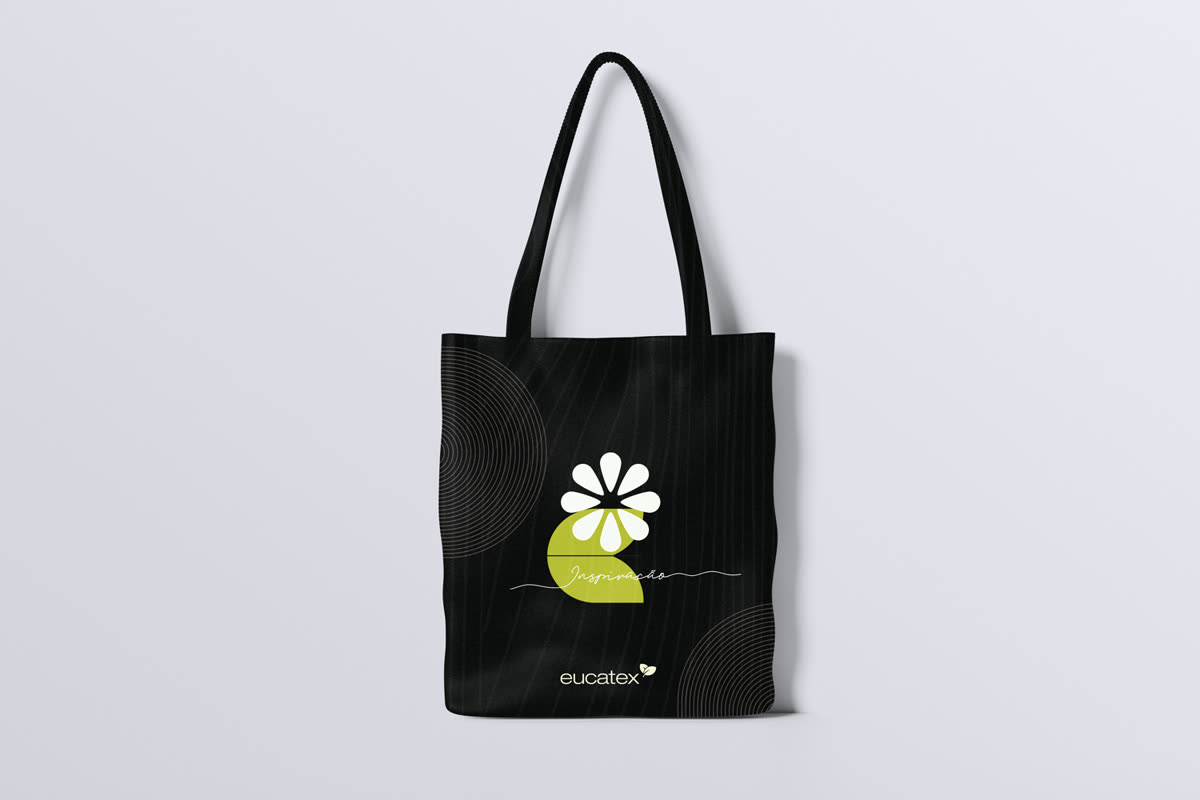 Ecobag preta com a flor branca sobre meia-lua verde e a assinatura Inspiração acima do logotipo eucatex.