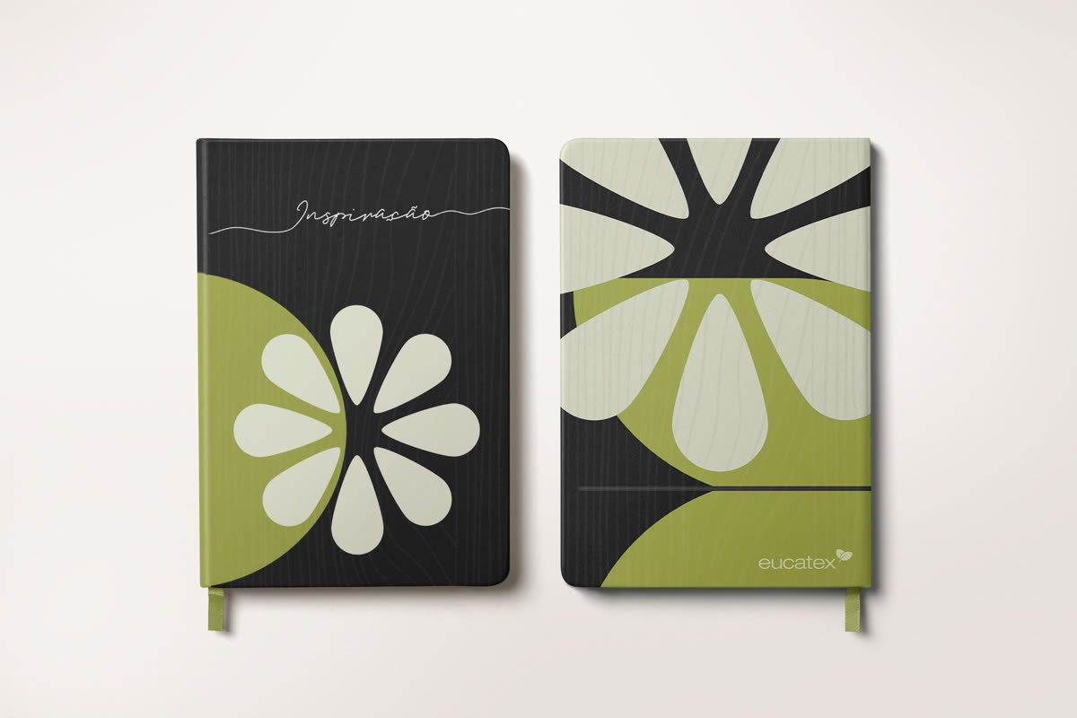Dois cadernos da linha, frente e verso, com o motivo floral em verde e off-white e a assinatura Inspiração.