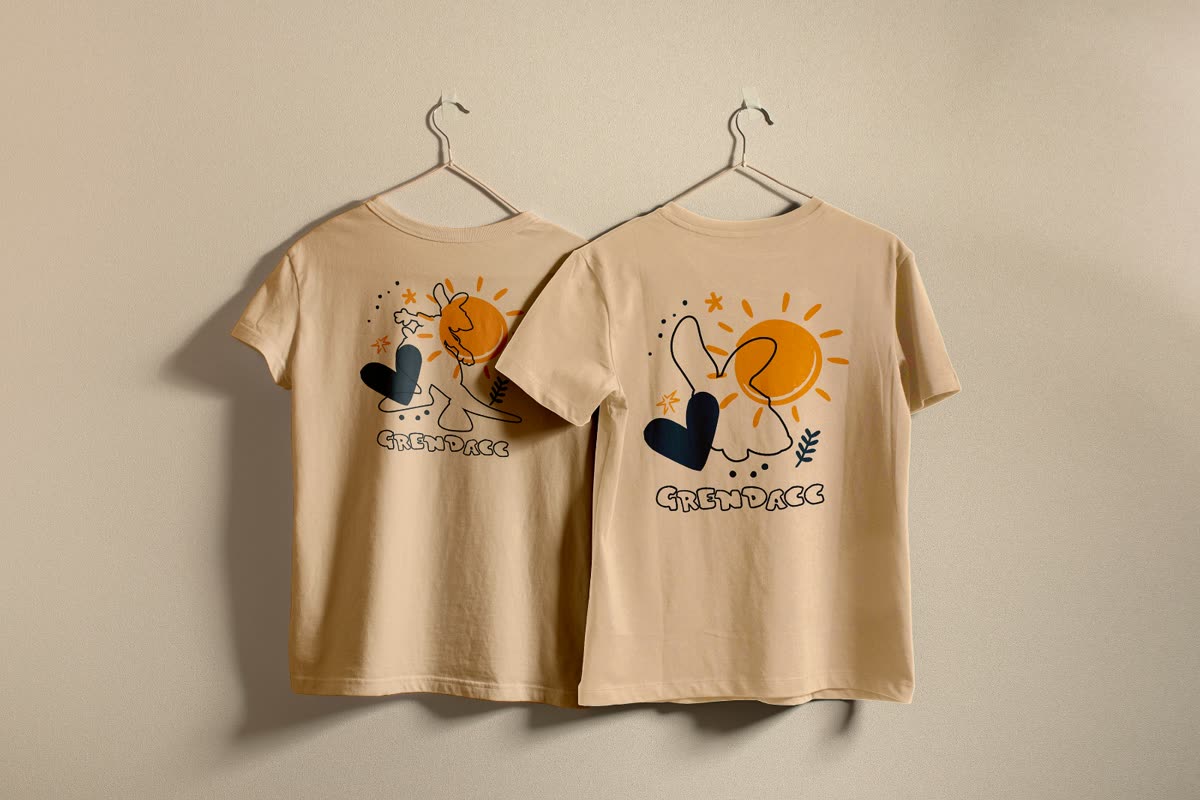 Duas camisetas bege com estampa de sol e coração e a marca Grendacc aplicada abaixo.